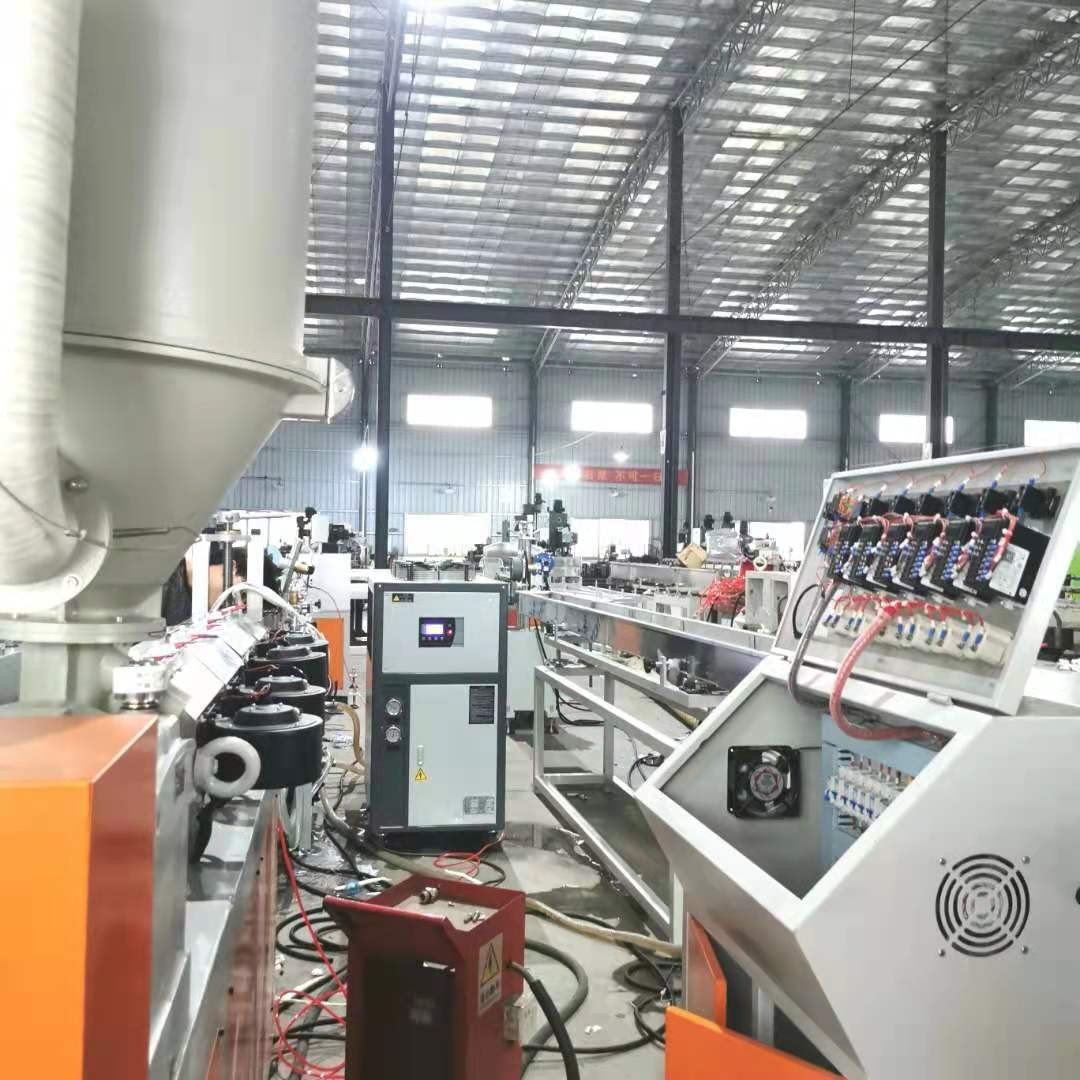 Plastic extrusion line with material hopper, temperature control unit and downstream equipment